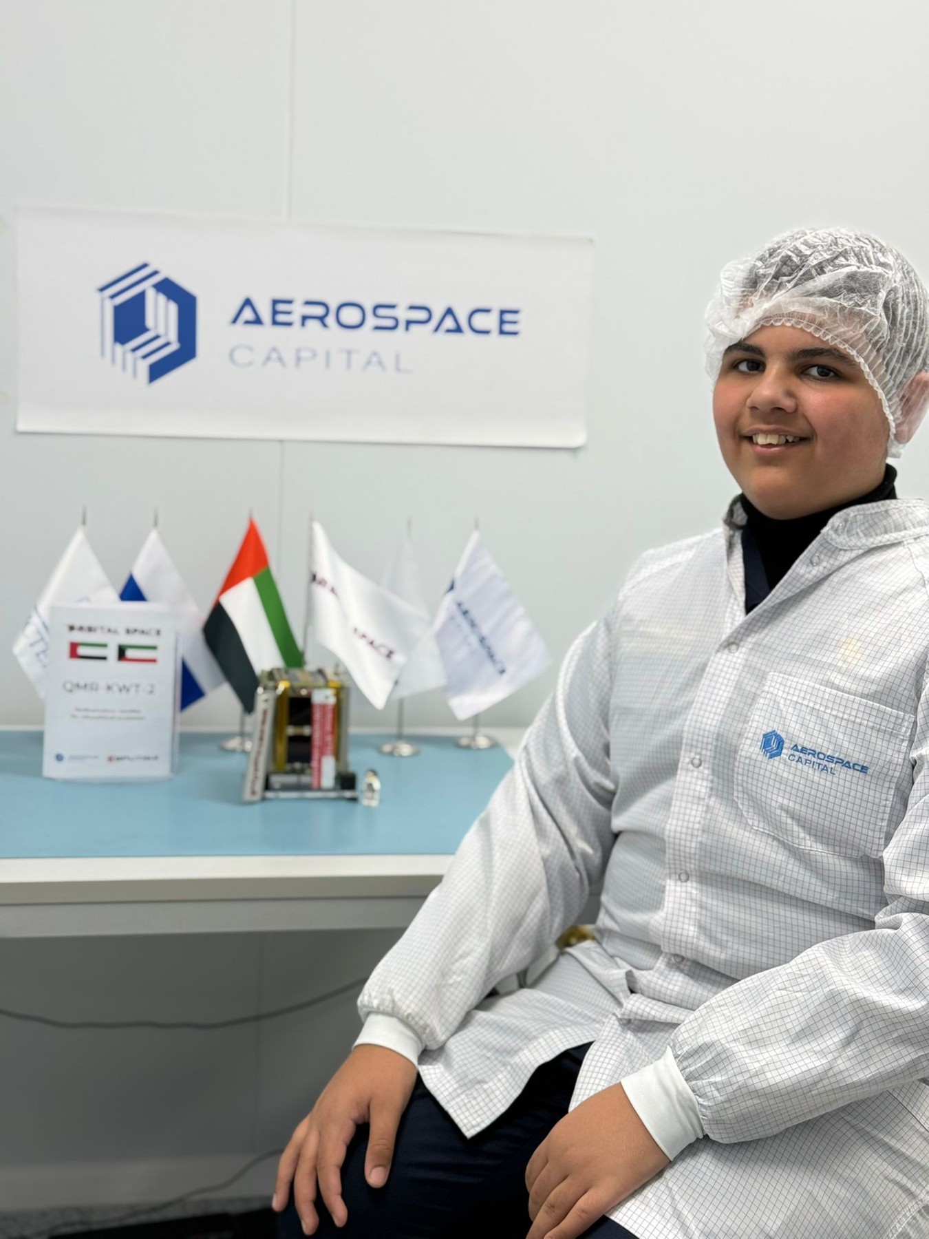 Student visitor with QMR-KWT-2 flight hardware in the cleanroom